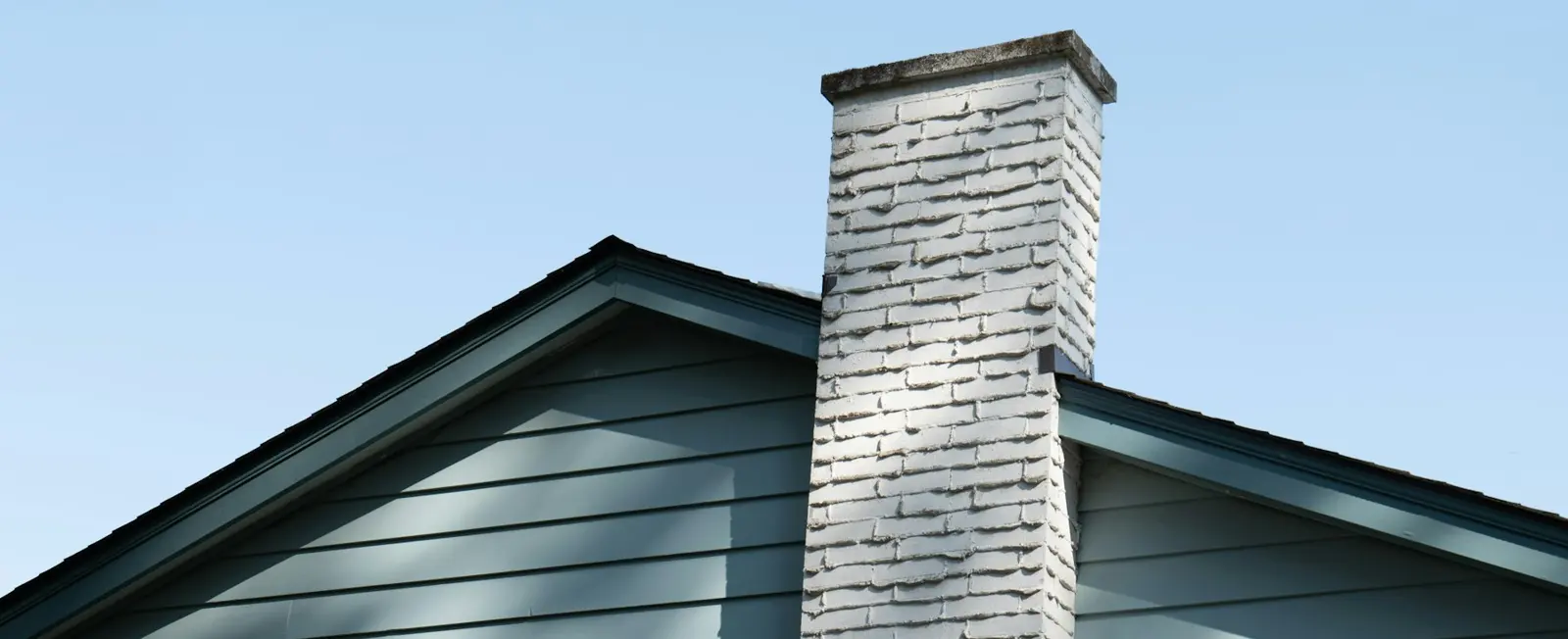 Painted brick chimney on a gabled roof