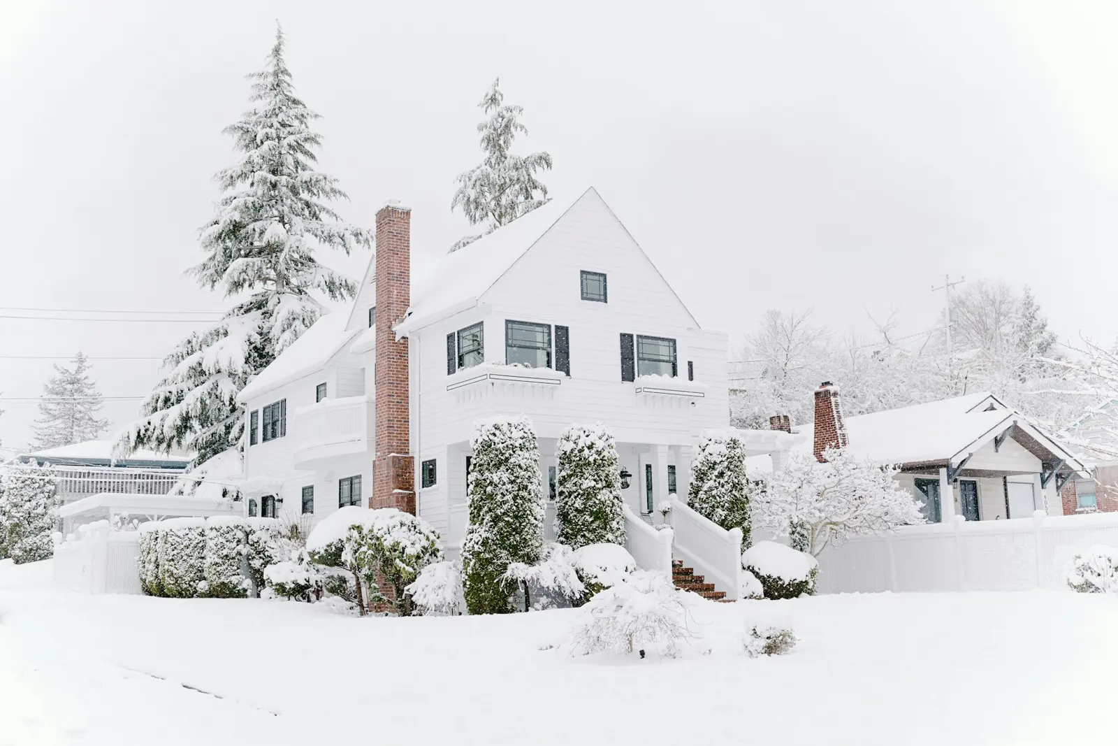 House with a brick chimney after a heavy snowfall